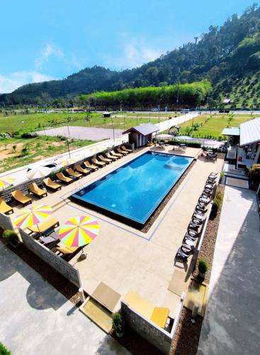 a swimming pool with lounge chairs and umbrellas at Golden sand khaolak Resort in Khao Lak