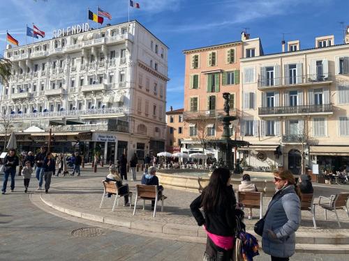 a group of people walking around a city with buildings at Palais des festivals Studio meublé in Cannes