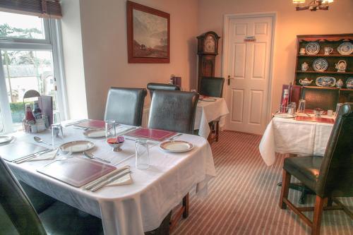 a dining room with a white table and chairs at The Mayhill Hotel in Monmouth