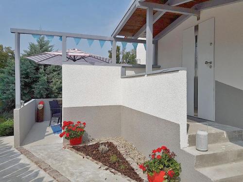 una casa con un porche con flores en macetas en Maisonette-Wohnung mit großer Terrasse - 11a, en Maximiliansau