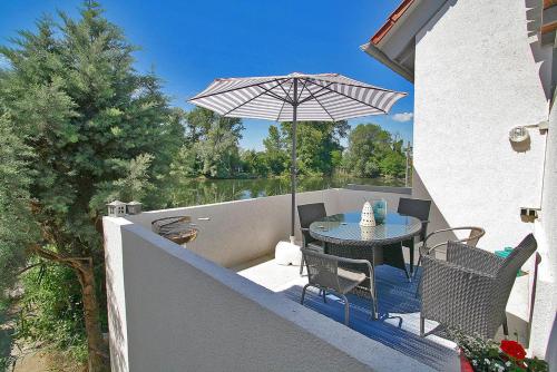 un patio con una mesa y una sombrilla en Maisonette-Wohnung mit großer Terrasse - 11a, en Maximiliansau