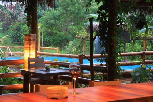 a glass of wine sitting on a wooden table at La Bicok EcoLodge in Mindo