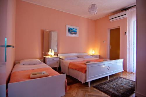 2 camas en un dormitorio con paredes de color naranja en Apartment and Rooms Toka, en Zadar