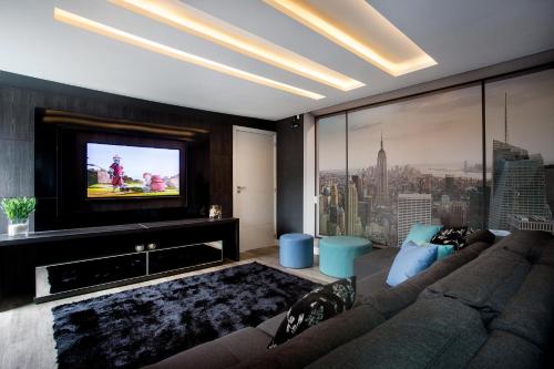 un salon avec un canapé et une télévision à écran plat dans l'établissement Pousada Gaúcha, à Bombinhas