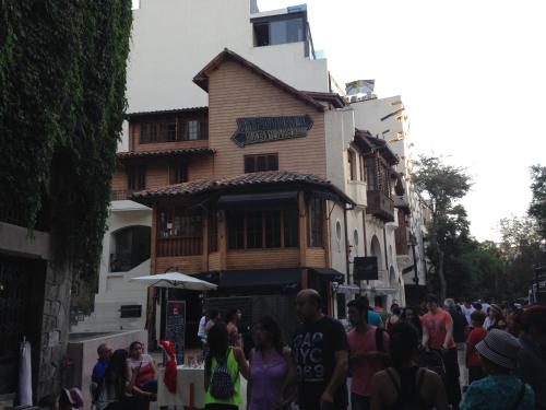 a crowd of people walking down a street in front of a building at Azzaí Bellas Artes in Santiago