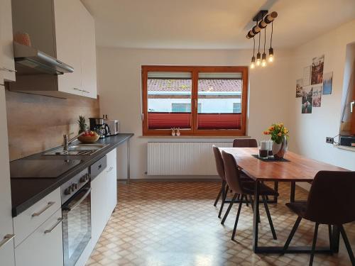 eine Küche mit Tisch und ein Esszimmer in der Unterkunft LECHUFER, 80m2, Haushälfte mit privatem Eingang, Kaminofen, Terrasse, Garten in Pinswang