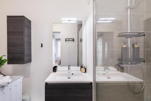 a bathroom with two sinks and a shower at Chic & Cozy Living - Near Heart of Paris in Clichy