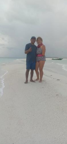 a man and a woman standing on the beach at Amaro Homestay in Nuhu Tawun