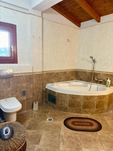 a bathroom with a tub and a toilet at Villa Kalli - Porto Ennia in Vromopoúsi