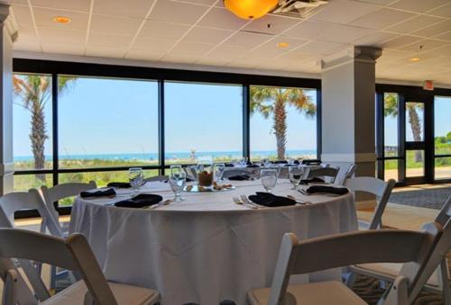 a dining room with a white table and chairs at Shell Island Resort - All Oceanfront Suites in Wrightsville Beach