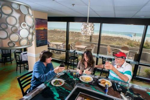 a group of people sitting at a table in a restaurant at Shell Island Resort - All Oceanfront Suites in Wrightsville Beach