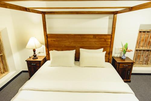 a bedroom with a large bed with white sheets and pillows at White on White in Hikkaduwa