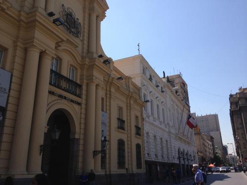 a building with a clock tower on the side of a street at Azzaí Bellas Artes in Santiago