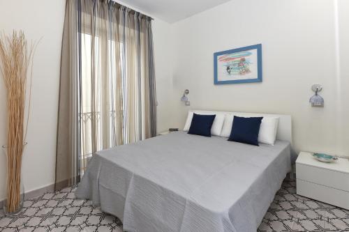 a bedroom with a large bed with blue pillows at Ravello House in Ravello
