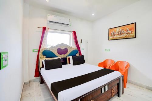 a bedroom with a bed and an orange chair at Hotel krishna manu place in Orchha