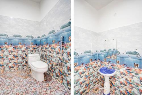 a bathroom with a toilet and a mural of chickens at Hotel krishna manu place in Orchha