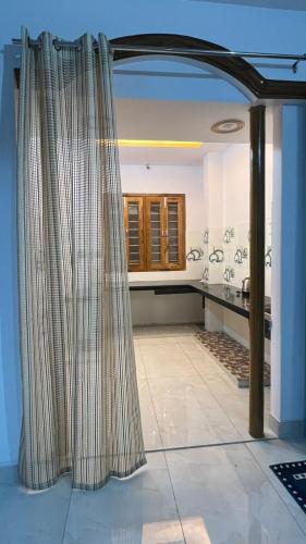 a bathroom with a shower curtain in a room at Aadya's Blessed Home in Prayagraj