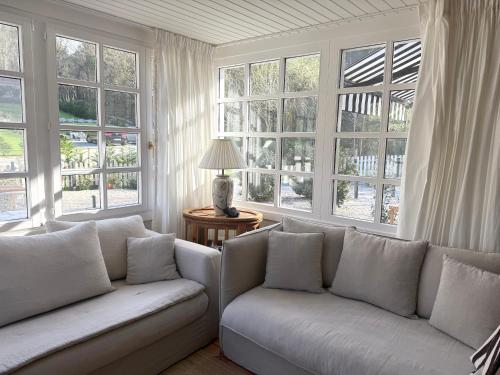 a living room with two couches and large windows at GURAH Boutique Apartments in Bakio
