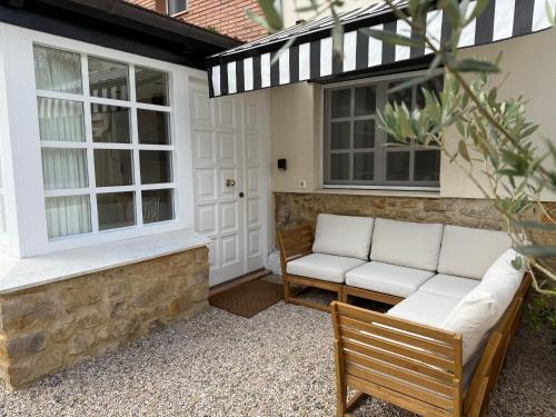 a patio with two white couches and two windows at GURAH Boutique Apartments in Bakio
