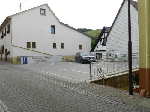 a car parked in a parking lot next to two white buildings at Weingut Stassen in Oberheimbach