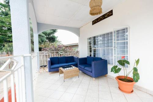 a patio with blue couches and a table at Inkindi House in Kigali