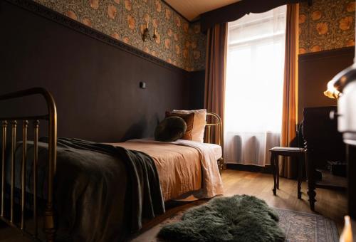 a bedroom with a bed with a cat sitting on it at Le 1930 in Hénin-Beaumont