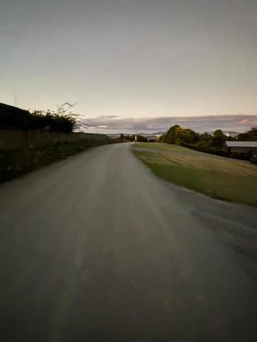 an empty road with the ocean in the distance at Ruakaka Retreat in Ruakaka