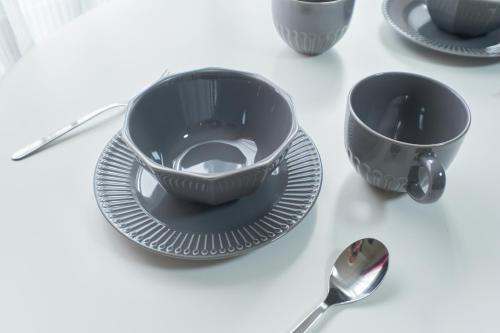 a table with two cups and plates and a spoon at Ruygo Setagaya by Tranova in Tokyo