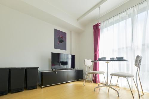 a living room with a tv and a table and chairs at Ruygo Setagaya by Tranova in Tokyo