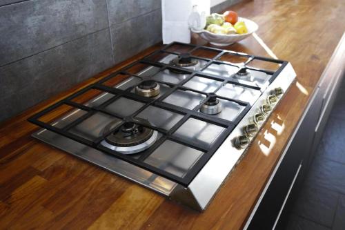 a stove top in a kitchen with a bowl of fruit at Villa DEA - Home away from home - Families Only in Salou