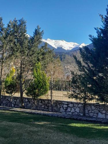 a fence with snow capped mountains in the background at Chalet Styga Kalavrita in Kalavrita