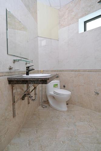 a bathroom with a white toilet and a sink at Khách sạn Hoàng Hà River Town in Yên Bái
