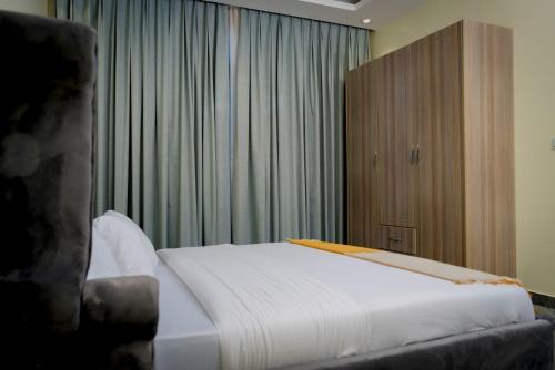 a bedroom with a white bed and a large window at La Petite Résidence- Private in Kigali