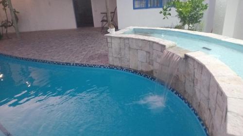 a swimming pool with a stone retaining wall next to a swimming pool at Reeds House - a place to feel at home in Queenstown