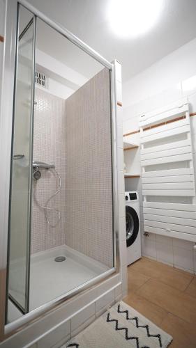 une douche avec une porte vitrée dans une salle de bain dans l'établissement Appartement bien-être Issoire, à Issoire