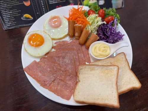 um prato de café da manhã com ovos, carne, torradas e vegetais em The BRC Ao-nang Hotel em Praia de Ao Nang