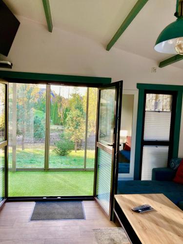 a living room with a large glass door to a yard at Leśne Domki Premium in Prokowo