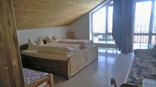 a bedroom with two beds in a room with windows at Gästehaus am Rathaus, Mehrbettzimmer 1 in Hohenpeißenberg