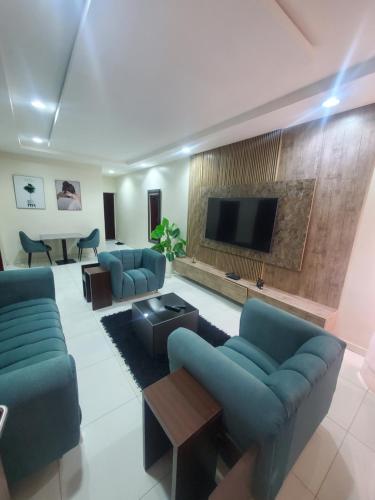 a living room with blue couches and a flat screen tv at LArt homes in Lekki