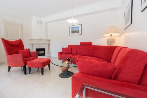 a living room with a red couch and chairs at Windeby 1T in Wenningstedt