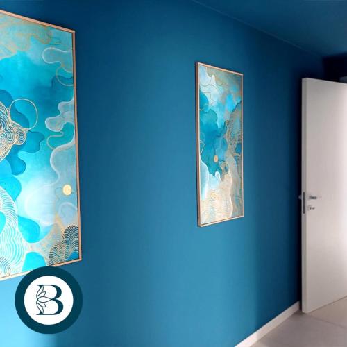 a blue wall with two pictures on it at BlueCharme modern apartment in Quartu SantʼElena