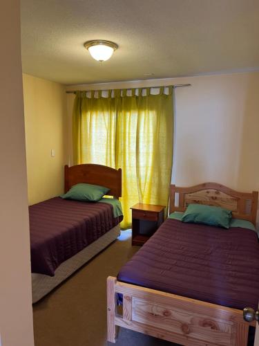 a bedroom with two beds and a window at Casas Amobladas y Equipadas Calama in Calama