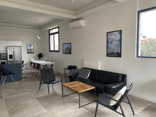 a living room with a couch and chairs and a table at Oikos Olympos in Ágios Spyrídon
