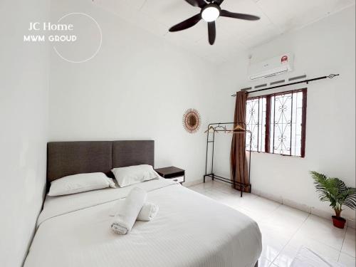 a bedroom with a bed with a ceiling fan at Kempas Kampung style 12pax Family Suites in Johor Bahru