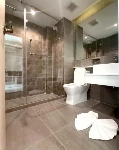 a bathroom with a shower and a toilet and a sink at The 9 Residence Hotel in Bangkok