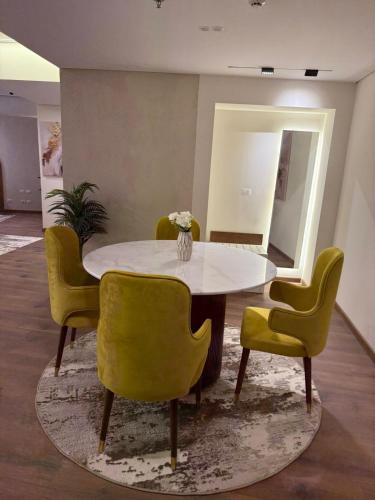 a dining room with a table and yellow chairs at Tolip Family Park Hotel in Cairo