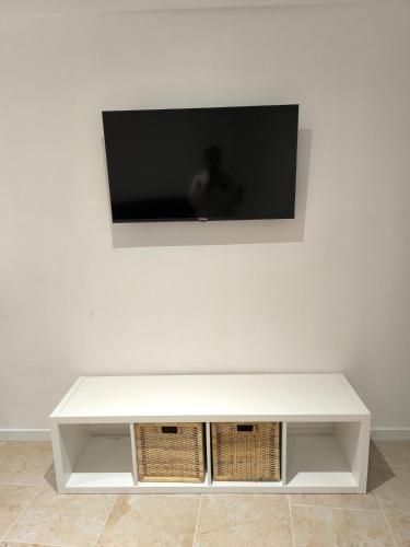 a white table with a television on a wall at Appartement avec une chambre et tout équipé dans centre ville in Montélimar