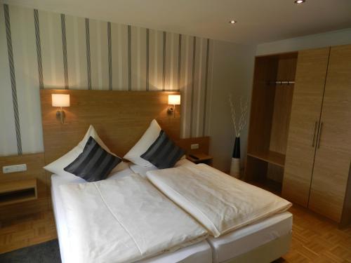 a bedroom with a large white bed with two pillows at Weingut Stassen in Oberheimbach