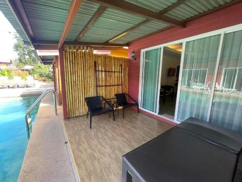 eine Terrasse mit Tisch und Stühlen neben einem Pool in der Unterkunft Lanta For Rest Boutique in Ko Lanta