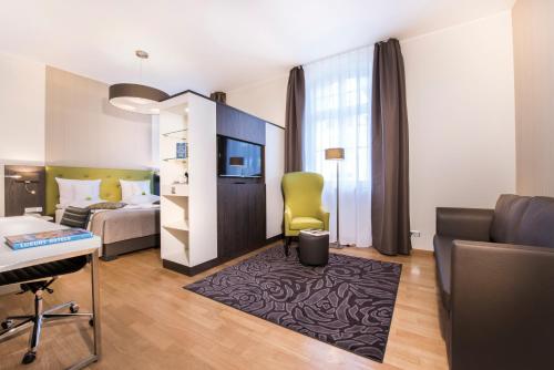 a hotel room with a bedroom with a bed and a desk at Collegium Leoninum in Bonn